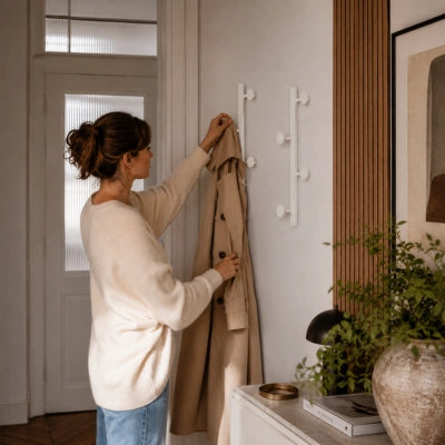 Femme accranchant son manteau sur la patère murale lea lifestyle blanche